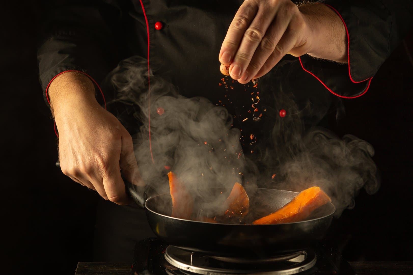 Chef Clayton searing in a pan over open flame